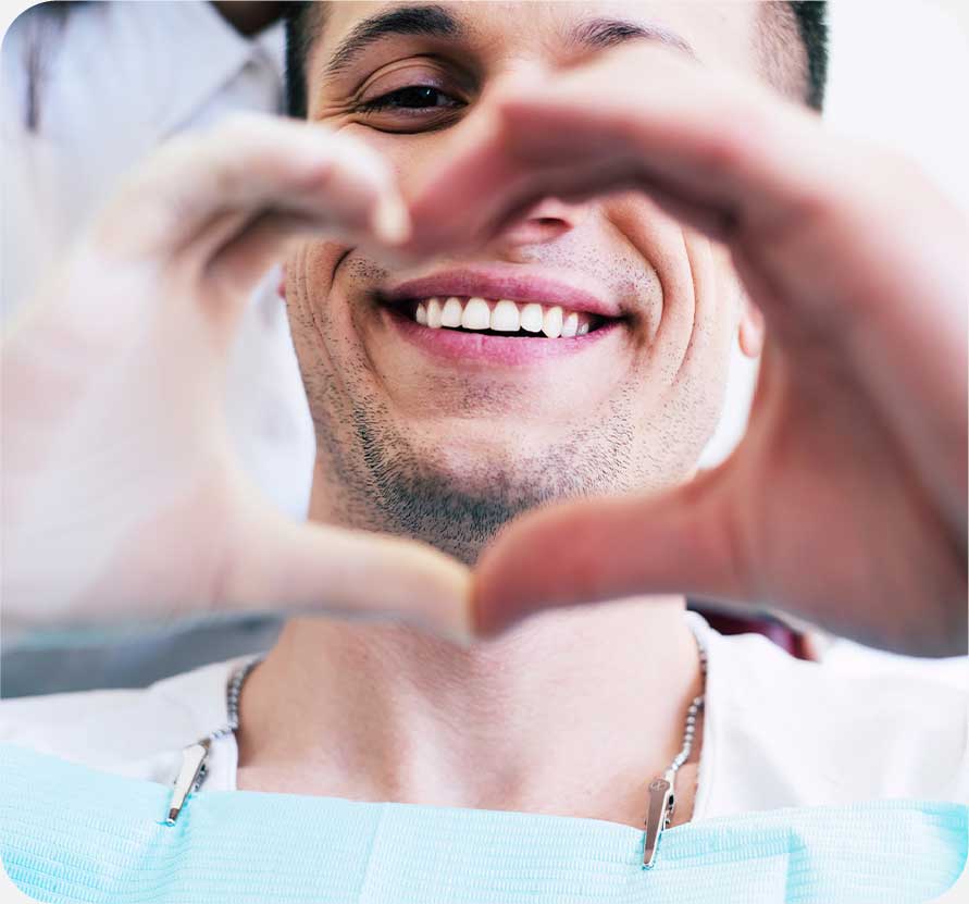 A medical professional forming a heart with their hands and smiling