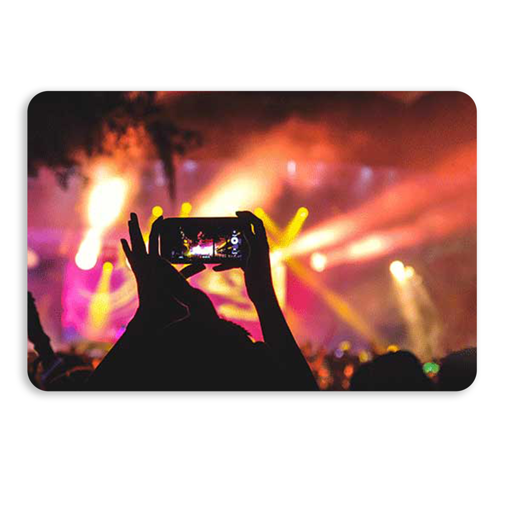 hands holding a cell phone, taking a picture at a concert