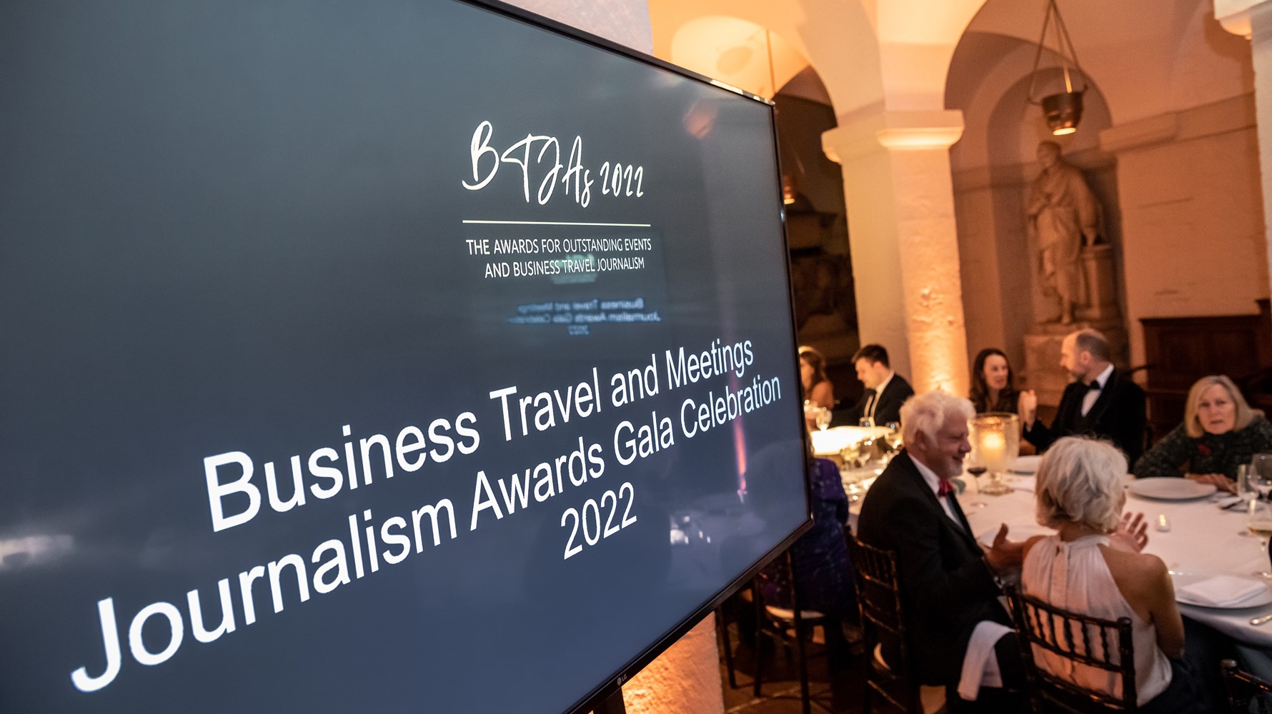 The winners of the Business Travel Journalism awards gathered on a stage with their awards. 